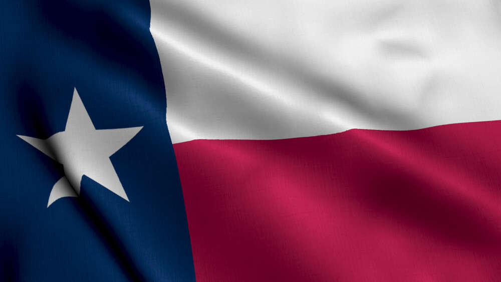 The image shows the Texas state flag, proudly displayed. It consists of a vertical blue stripe with a white star and horizontal white and red stripes. This symbol of pride can often be seen at Certified PDR Training centers across the state.